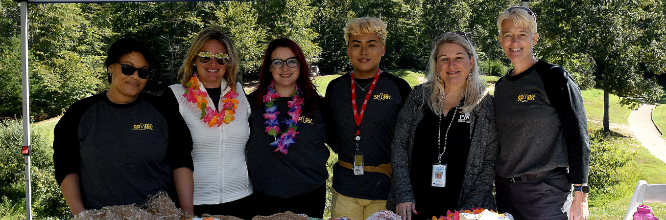 SPARK and PWCS employees at luau themed charity table at SPARK golf tournament