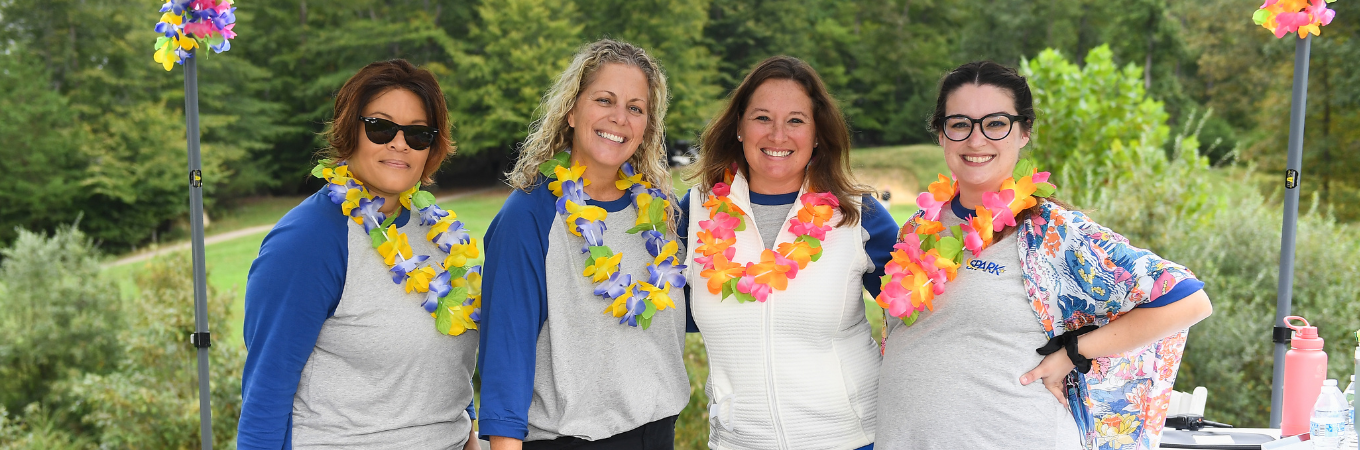 SPARK Executive Director, President, and staff working the "Good Vibrations" charity table at the Golf Tournament