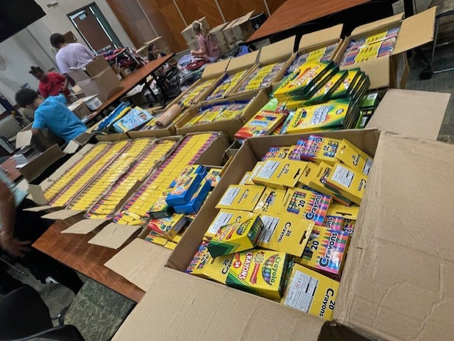 school supplies including large box containing large number of crayon boxes on table